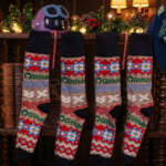 Four GitHub Ugly Holiday socks hanging on a shelf looking like stockings, the hat is hanging on the shelf too, and the amazeball is sitting on the shelf. The feeling is cosy and full of holiday cheer.