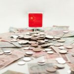 Chinese flag on top of some paper money and coins