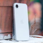 iPhone 16e leaning on flower box